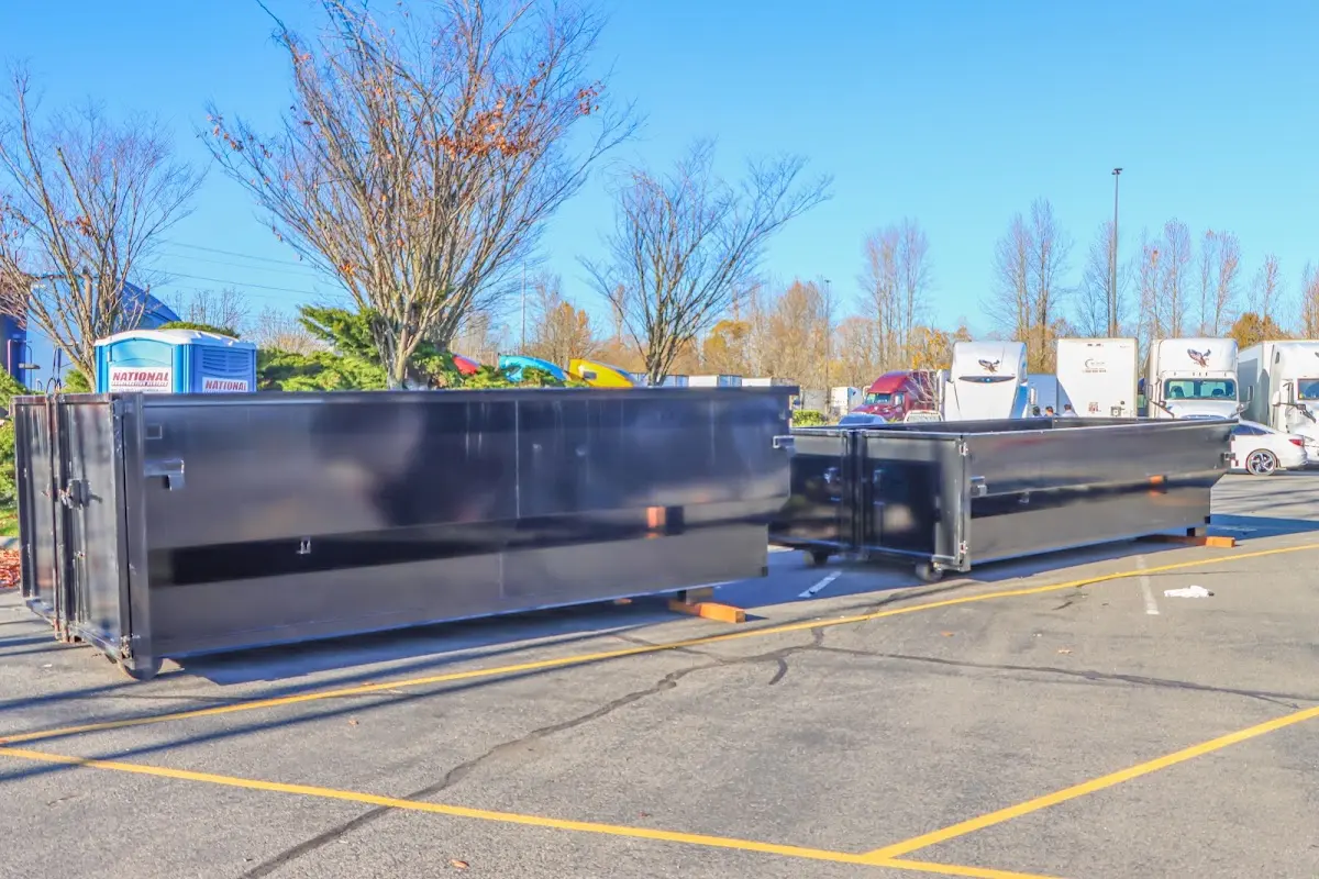 Professional dumpster rental service with roll-off container on residential driveway in Freeport